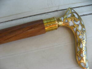 美しい貝面のような、真鍮まじりの握りの杖、ステッキ。インドローズ、バラ、飾られた杖。輸入